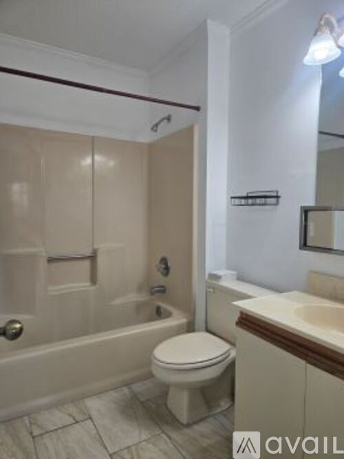 A bathroom with a toilet, sink, and bathtub.