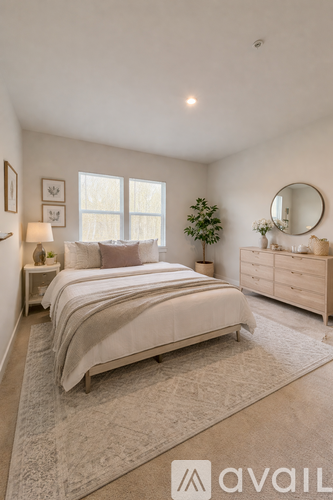A bedroom with a large bed, a dresser, and a mirror.