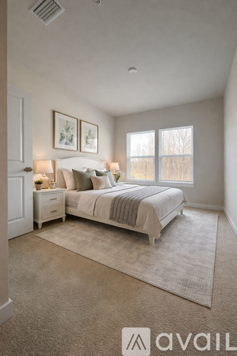 A bedroom with a bed, nightstands, and pictures on the wall.