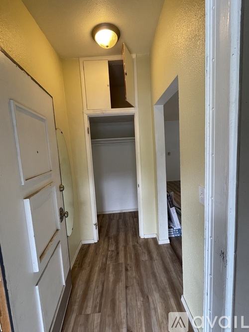 A narrow hallway with a white door on the left and a white door on the right.