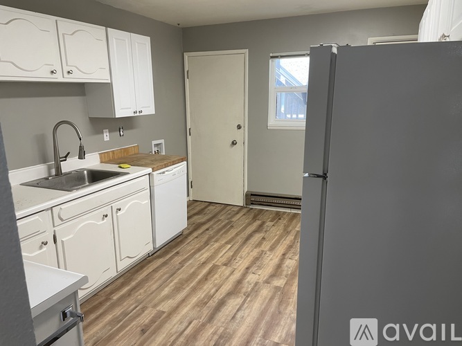 A kitchen with a refrigerator on the right side.