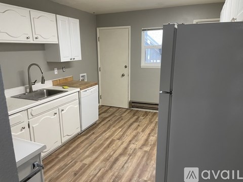 A kitchen with a refrigerator on the right side.