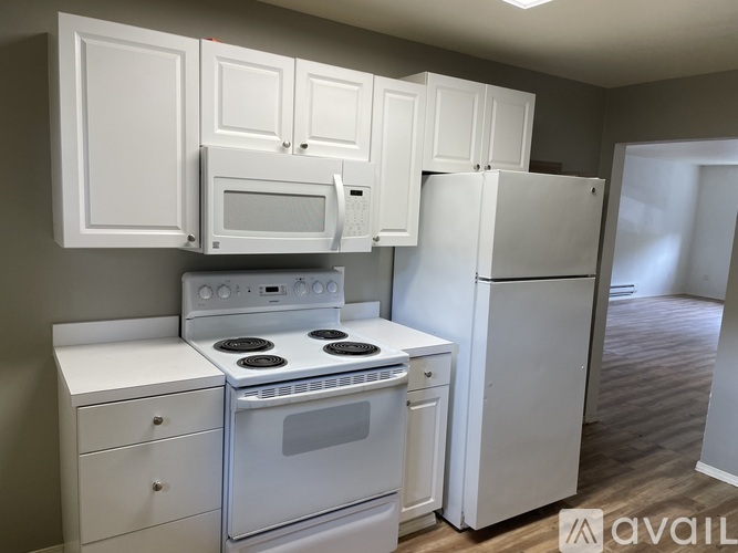 A kitchen with white appliances and cabinets.