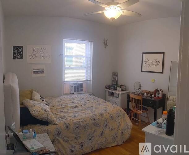 A bedroom with a bed, desk, and chair.