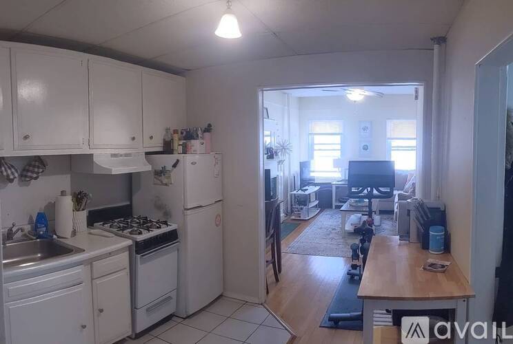 A kitchen with white appliances and cabinets.