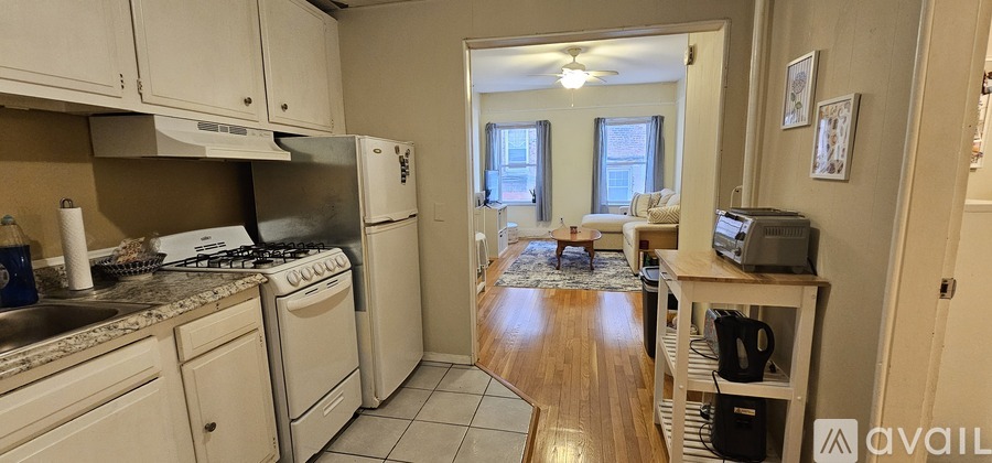 A kitchen with white cabinets and a stove top oven.