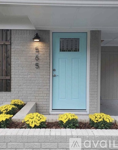 A blue door with a number 565 on the wall above it.