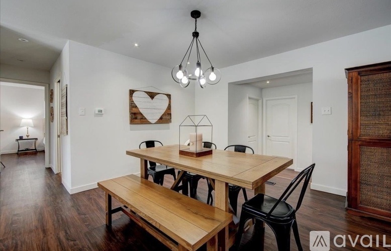 A dining room with a wooden table and chairs.