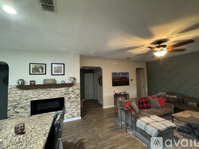 A living room with a stone fireplace and a couch.