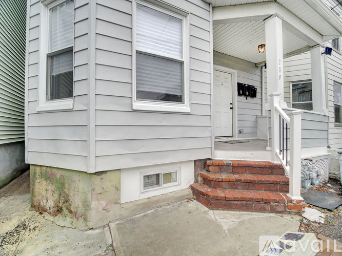 A house with a grey siding and a white door.