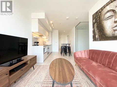 A living room with a red couch and a wooden coffee table.