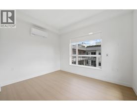 A room with a window showing a building outside.