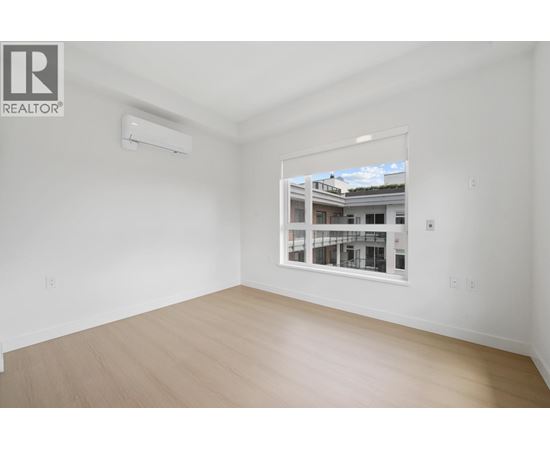 A room with a window showing a building outside.