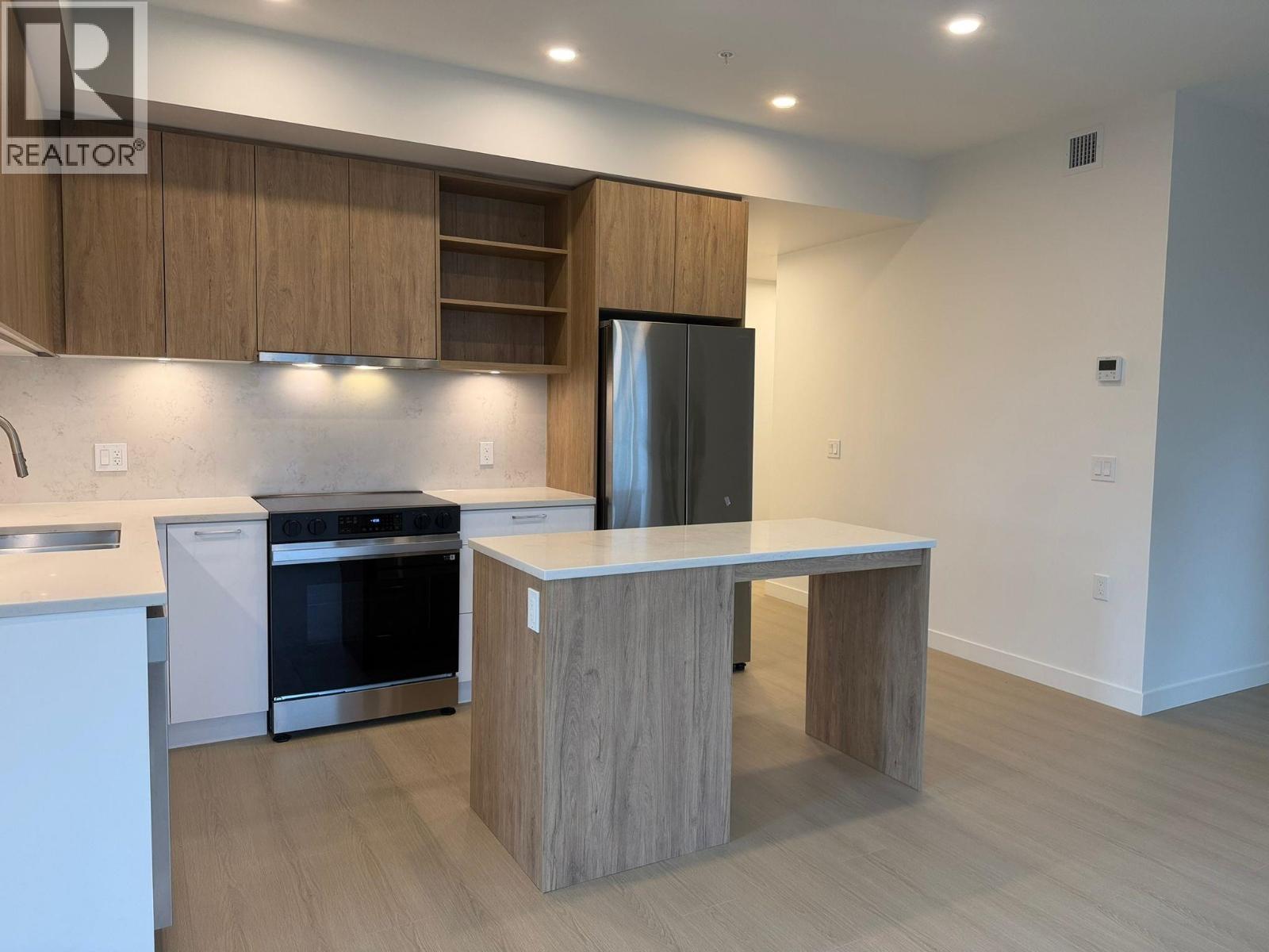 A modern kitchen with a wooden island and stainless steel appliances.