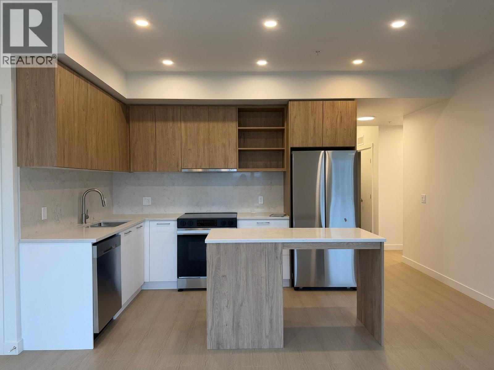 A modern kitchen with wooden cabinets and stainless steel appliances.