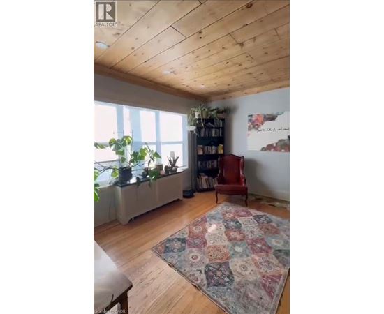 A room with a wooden ceiling and a rug on the floor.