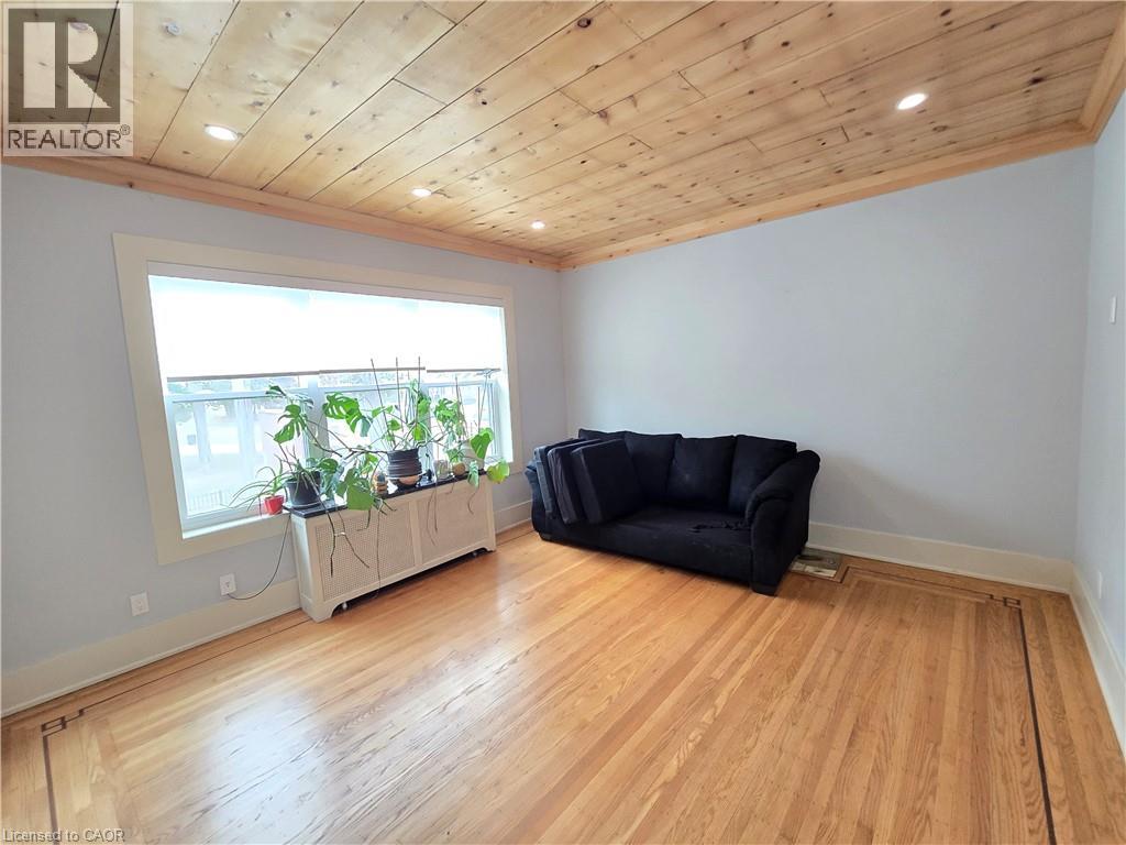 A living room with a black couch and wooden floors.