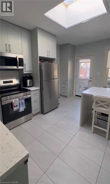 A kitchen with white cabinets and a refrigerator.