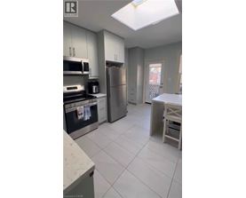 A kitchen with white cabinets and a refrigerator.