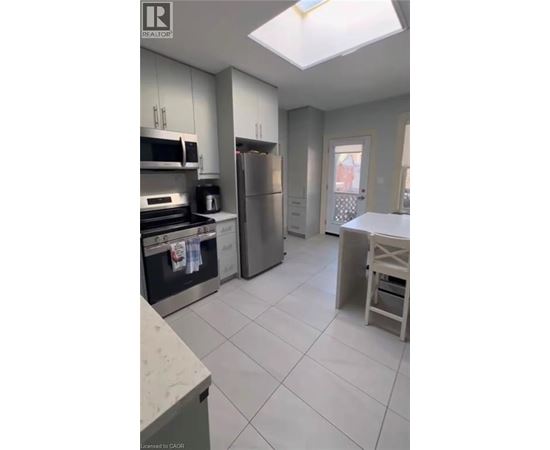 A kitchen with white cabinets and a refrigerator.