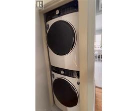 A white washing machine is installed in a narrow space.