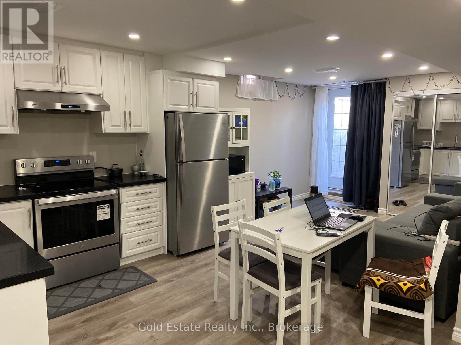 A kitchen with white cabinets and a black countertop.