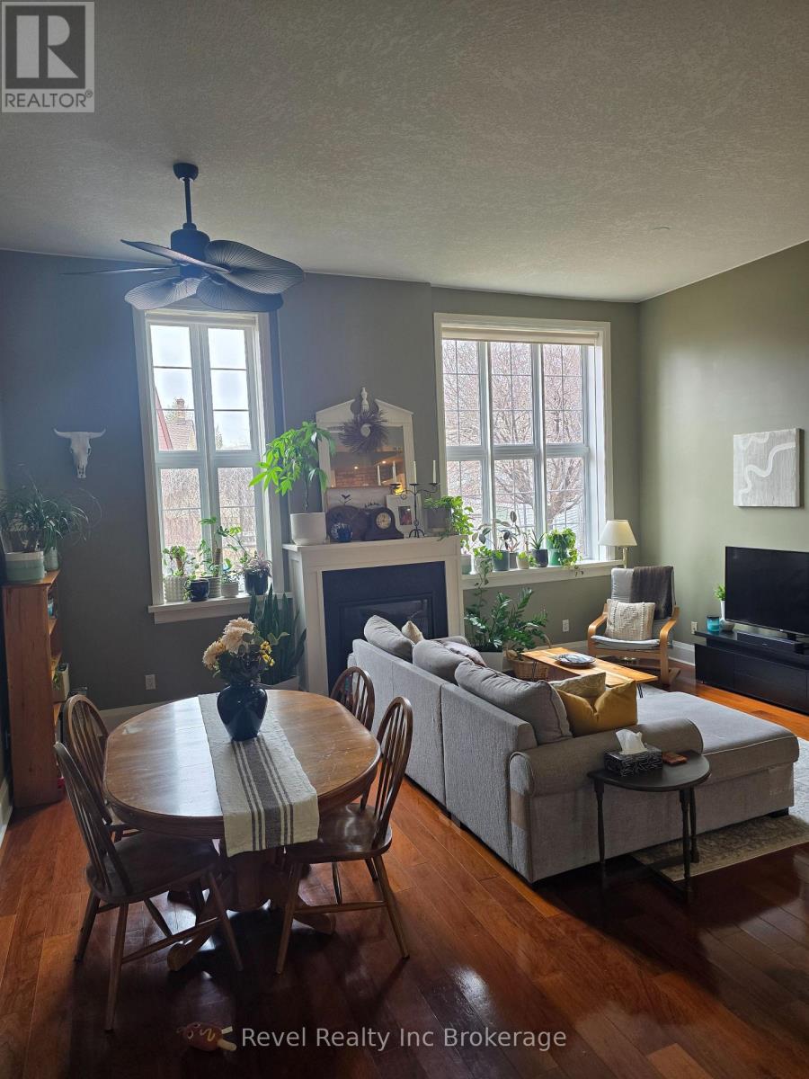 A living room with a couch, a table, a painting, a bookshelf, and a fireplace.