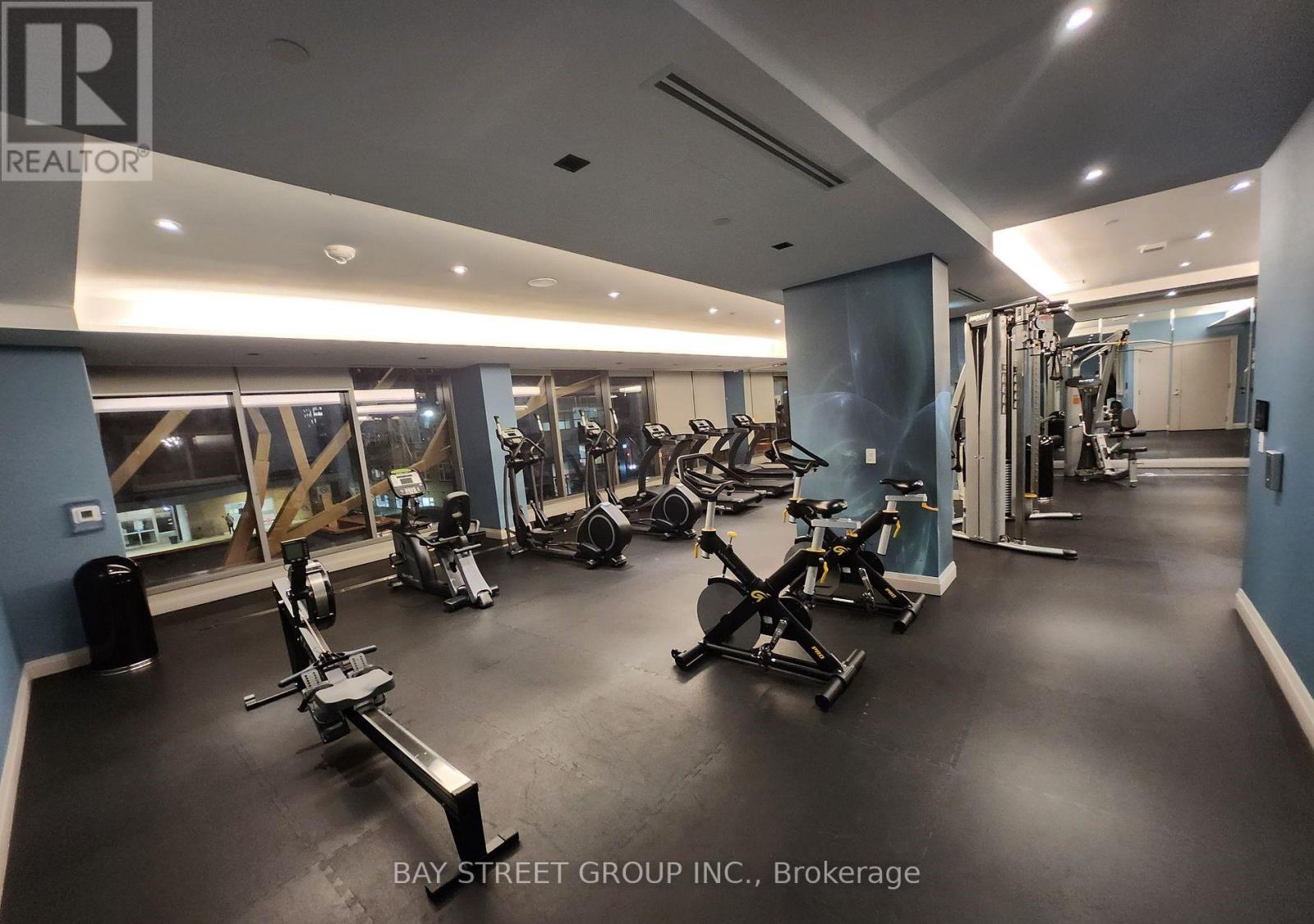 A gym with a variety of equipment including treadmills, stationary bikes, and weight machines.