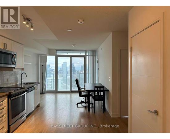 A kitchen with a dining table and chairs in front of a window with a view of the city.