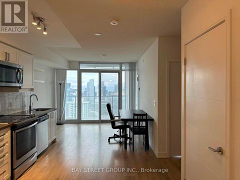 A kitchen with a dining table and chairs in front of a window with a view of the city.