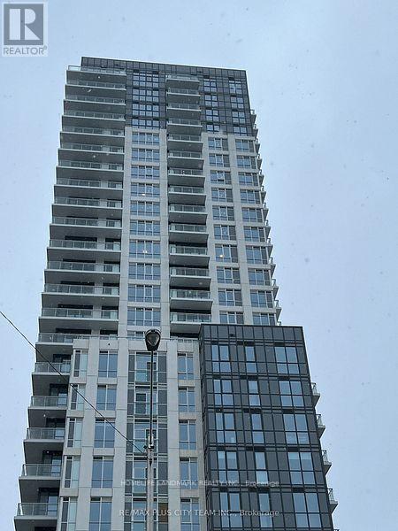 A tall building with many windows and balconies, and a sign that reads "REALTOR".
