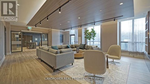 A living room with a couch, chairs and a plant.