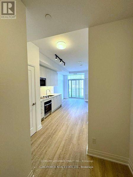 A well lit kitchen with white cabinets and a window.