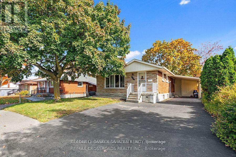 A house with a driveway and trees in front of it.