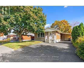 A house with a driveway and trees in front of it.