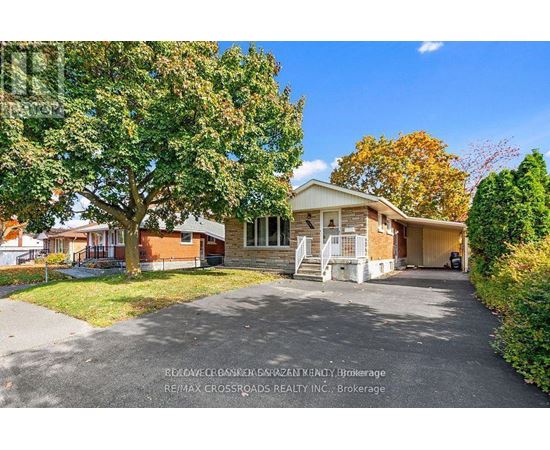 A house with a driveway and trees in front of it.