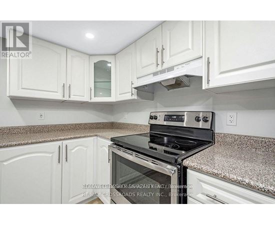 A kitchen with white cabinets and a granite countertop.