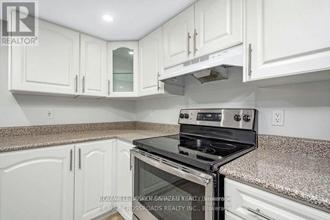 A kitchen with white cabinets and a granite countertop.