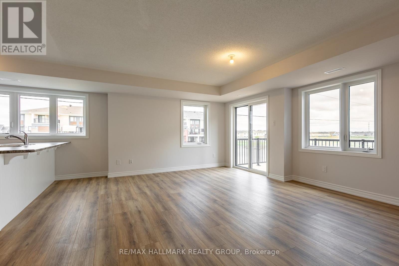 A spacious room with wooden floors and large windows.