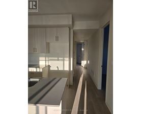 A realtor photo of a modern kitchen and hallway.
