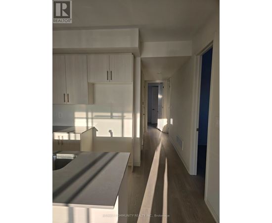 A realtor photo of a modern kitchen and hallway.
