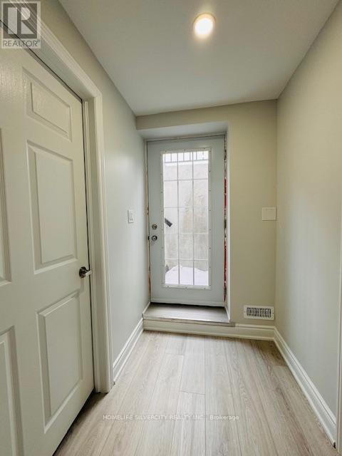 A hallway with a white door and a window.