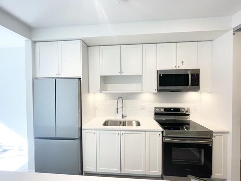 A kitchen with white cabinets and a black stove top oven.
