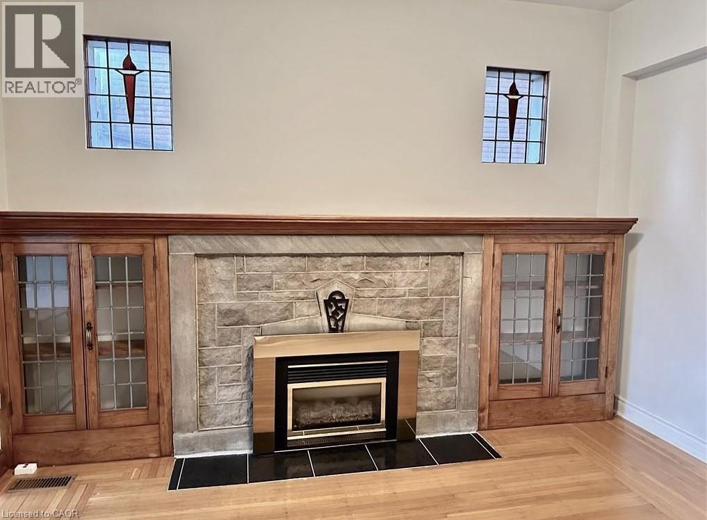 A fireplace with a stone surround and a wooden mantle.