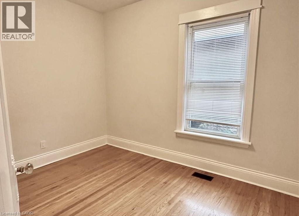 A room with a window and wooden flooring.