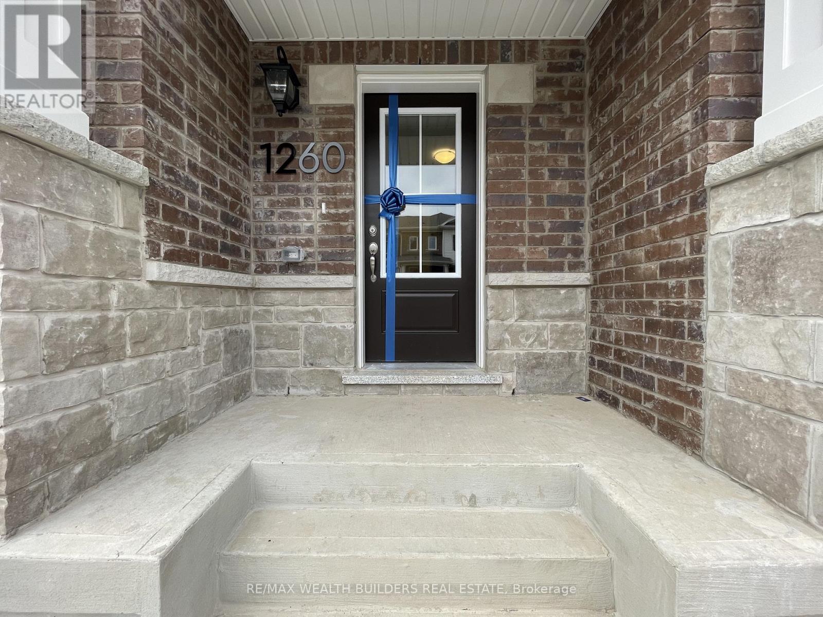 A house numbered 1260 with a blue door and a stone wall.