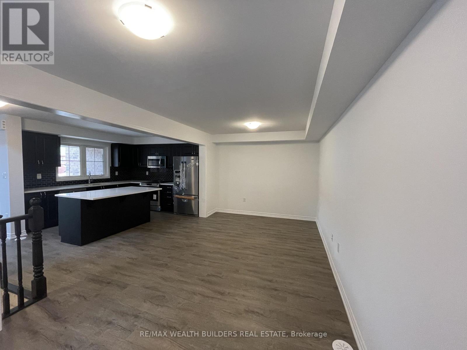 A spacious room with a pool table and a bar area.