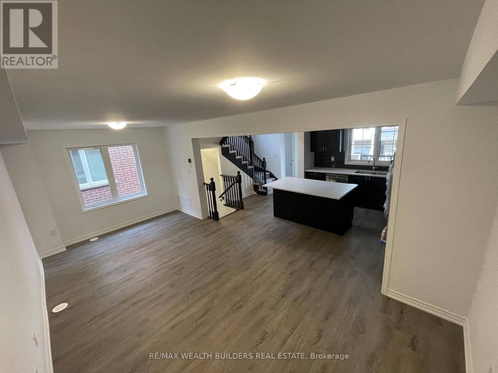 A spacious room with a staircase and a window.