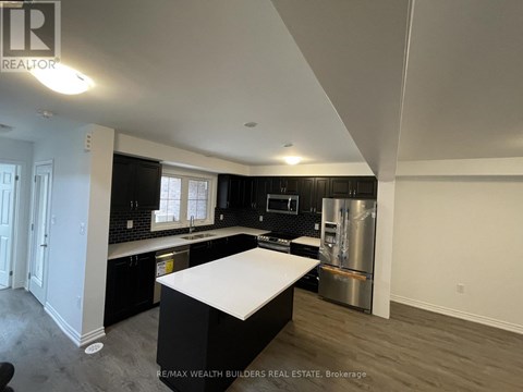 A kitchen with black cabinets and a white island.