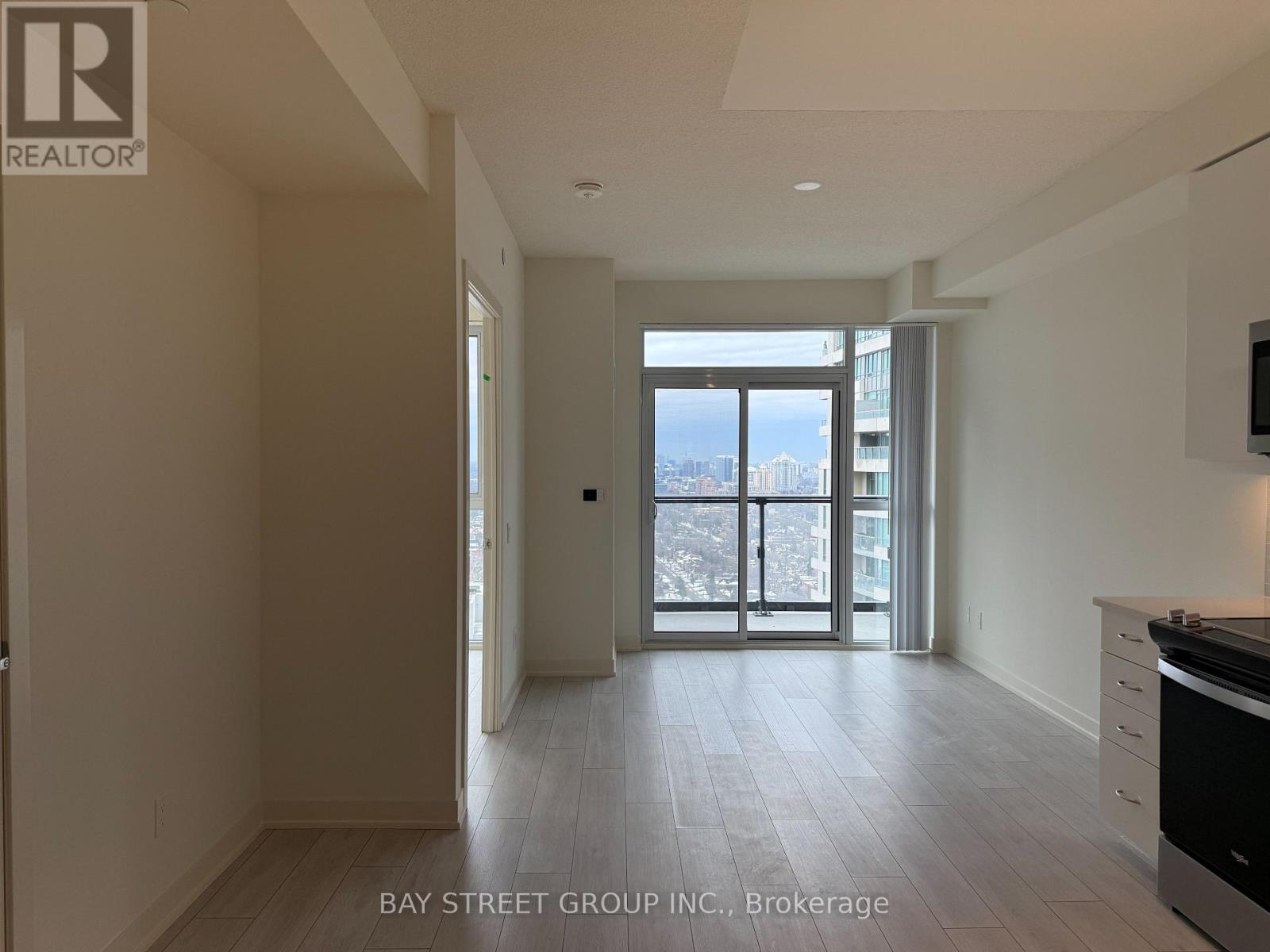 A spacious room with a view of the city through the sliding glass doors.